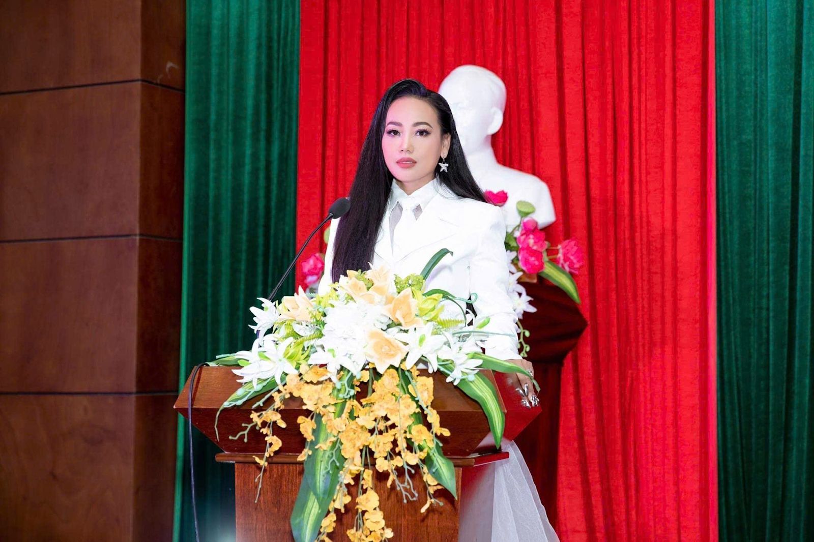 A person standing at a podium with flowersAI-generated content may be incorrect.